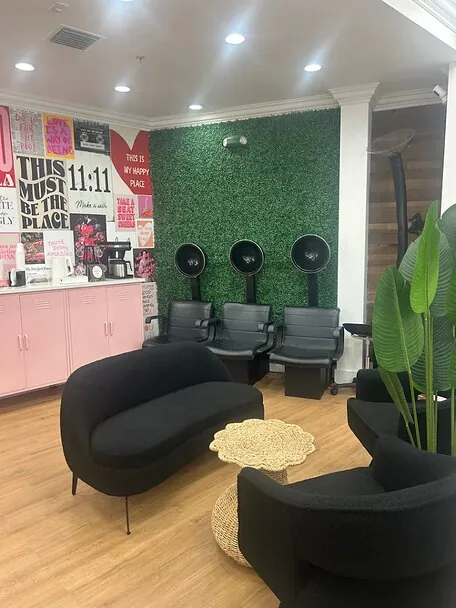 The Wild Orchid waiting area with its green moss wall and black seating